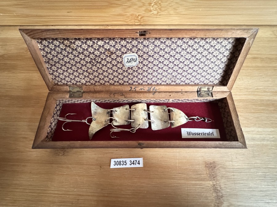 Gliederfisch „Wasserteufel“-Nachbildung – wie im DAM Katalog Fritz Ziegenspeck 1920 – wer keinen 4stelligen Betrag für ein Original ausgeben will, kann sich für einen kleinen Bruchteil seine Vitrine ergänzen. Es gibt 3 Exemplare davon. Der Köder ist mit „2505“ gepunzt. Es ist das 13 cm Modell in einem schönen Holzetui.